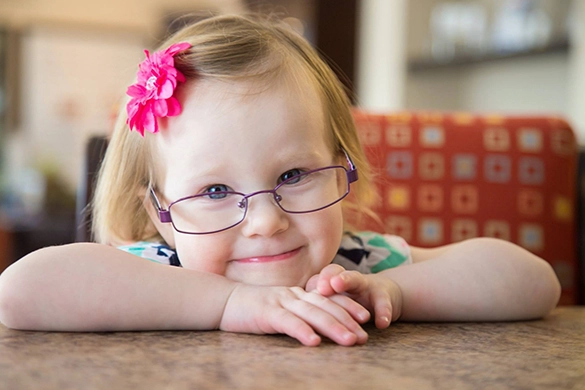 Eye Doctor Piqua OH Little Girl Smiling HP Little Girl With Glasses Smiling In Waiting Room Chair